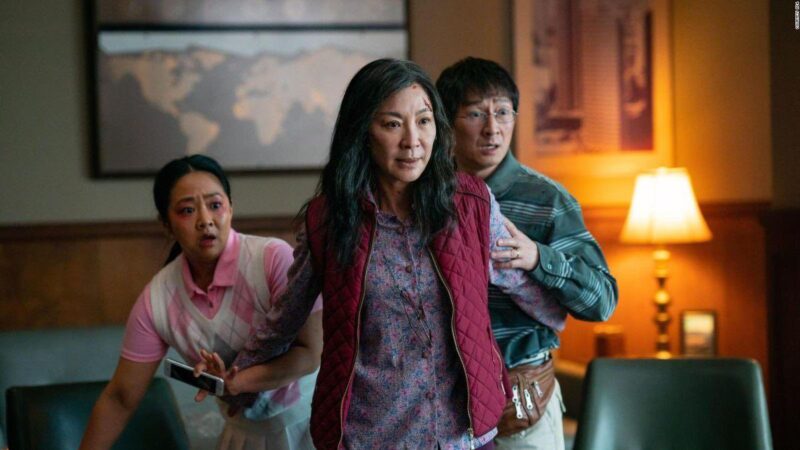 Evelyn Wang (Michelle Yeoh) from 'Everything Everywhere All at Once' steps back in a protective stance, shielding her husband, Waymond Wang (Ke Huy Quan), and Joy Wang (Stephanie Hsu).
