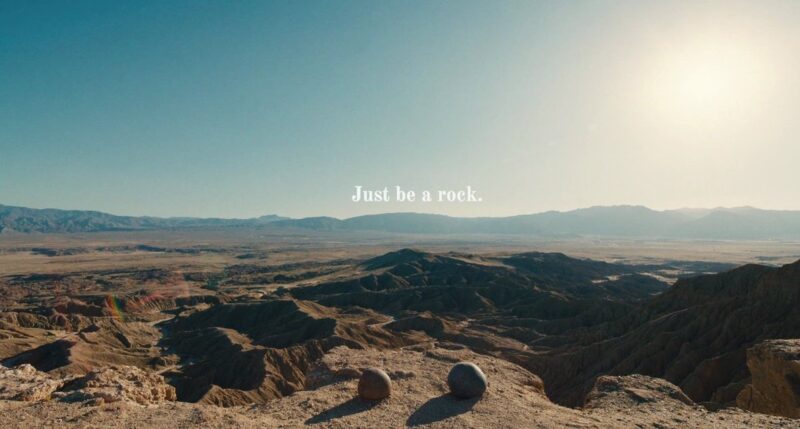The poignant 'Just be a rock' scene from 'Everything Everywhere All At Once', featuring two stones amidst a vast desert landscape.