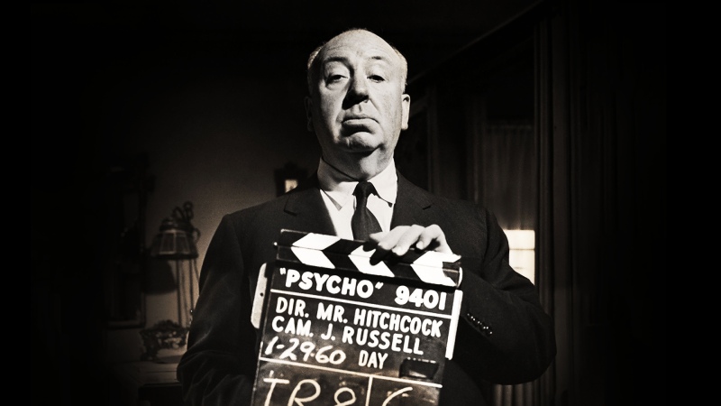 Alfred Hitchcock holding a Psycho clapperboard.