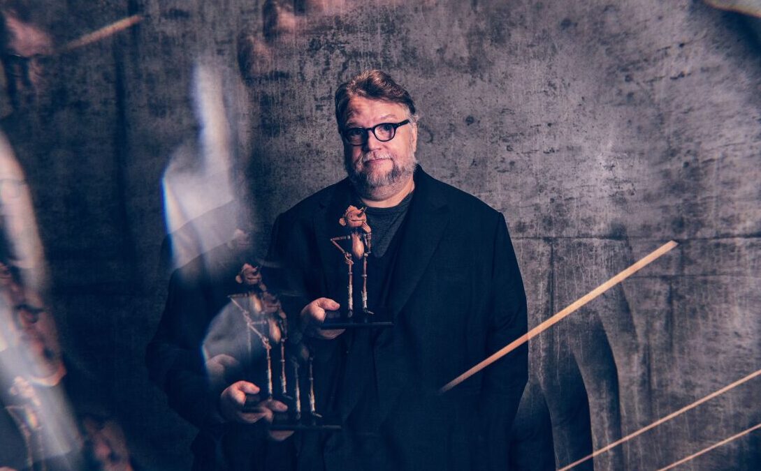 Guillermo del Toro holding a Pinocchio statue, showcasing his fascination with the beloved character.