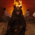 Midsommar's Shocking Ending: What It Really Means for the Characters! A man in a bear suit sits unaware that he will soon be burned.