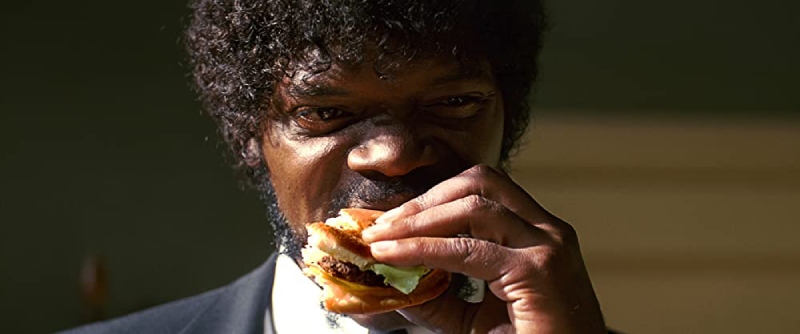 Image of Jules Winnfield (Samuel L. Jackson) eating a burger, moments before a violent killing scene, from the movie Pulp Fiction.