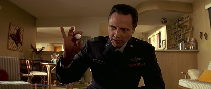 Image of a gold watch being held up by a character's hand, with a close-up view of the watch face, from the movie Pulp Fiction.