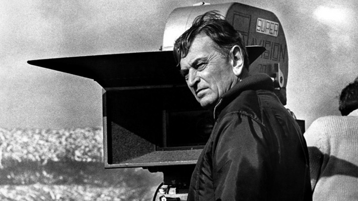 David Lean, the acclaimed filmmaker, strikes a charismatic pose on the movie set, exuding creative energy.