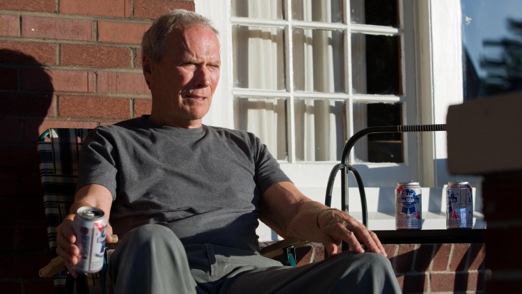 Walt Kowalski (Clint Eastwood) from Gran Torino, enjoying a relaxed moment while sunbathing with a beer and observing the neighborhood.
