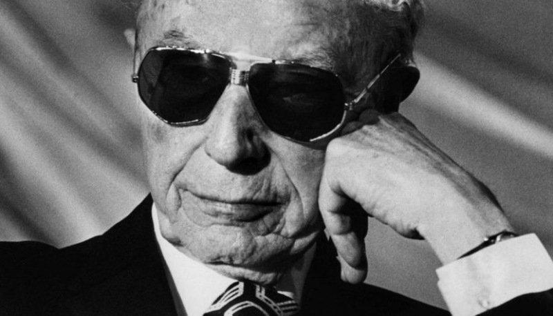 Close-up of Douglas Sirk, the acclaimed filmmaker, wearing glasses, with his head resting on his hand in a contemplative pose.