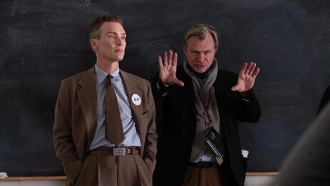 Christopher Nolan, the director of the Oppenheimer movie, gesturing to set the camera angle, with Cillian Murphy beside him, hands in pockets, preparing for his role.