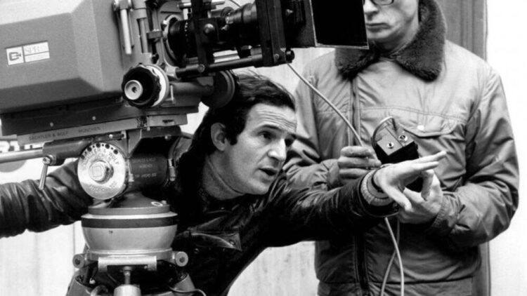 François Truffaut stands behind the camera, skillfully directing the film by orchestrating the surroundings.