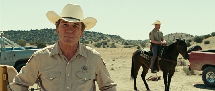 Tommy Lee Jones as Sheriff Ed Tom Bell in 'No Country for Old Men,' carefully inspecting a crime scene.