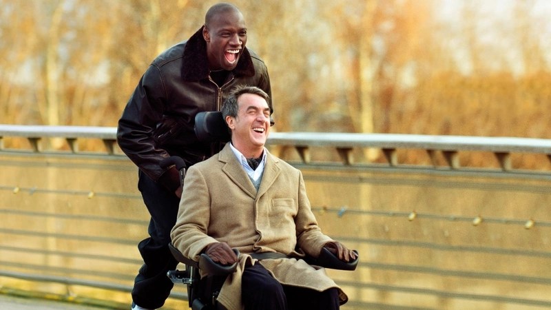 A joyful moment from the film "Intouchables" with Omar Sy as Driss and François Cluzet as Philippe, as Driss excitedly runs around in Philippe's wheelchair.