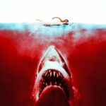 The Shocking Truth: How "Jaws" Manipulated Minds and Created Shark Phobia! The infamous "Jaws" movie scene - a shark cruising in the water against a vivid red background.