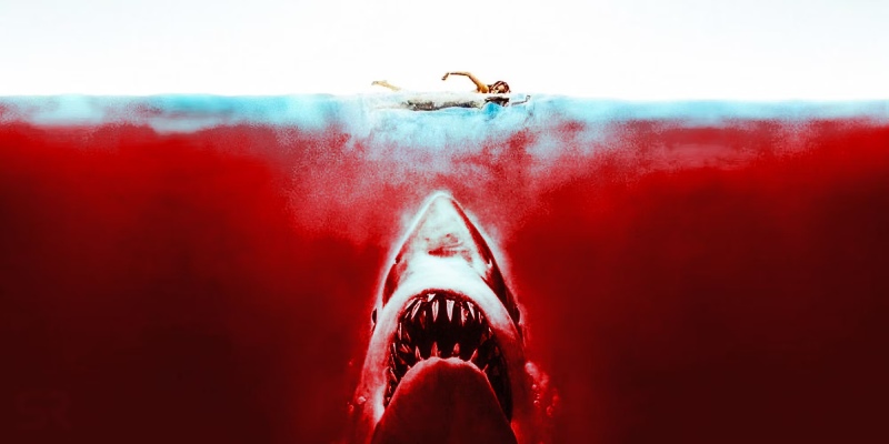 The infamous "Jaws" movie scene - a shark cruising in the water against a vivid red background.