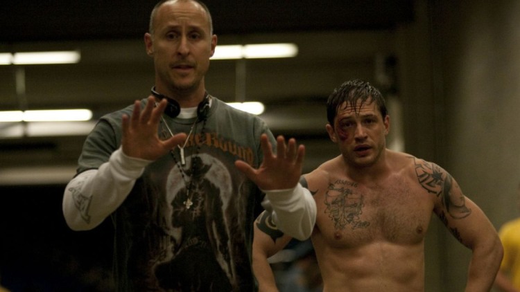 A shot of director Gavin O'Connor and actor Tom Hardy in character as Tommy Conlon, standing together.