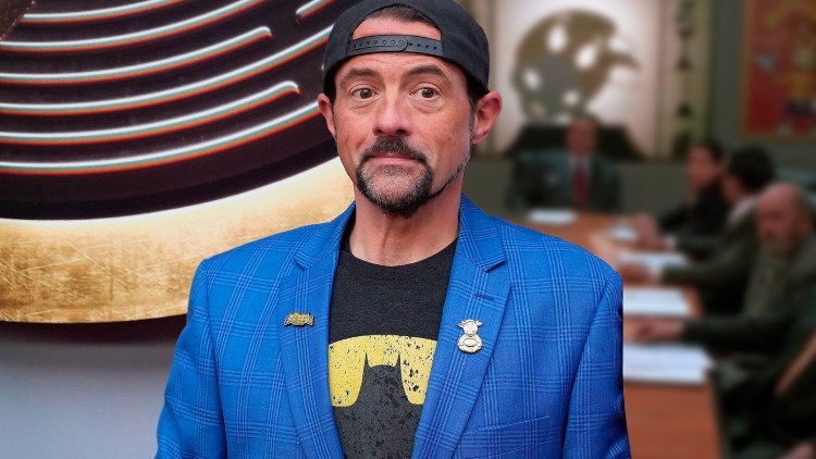 Kevin Smith wearing a shirt over a t-shirt and a cap on his head.