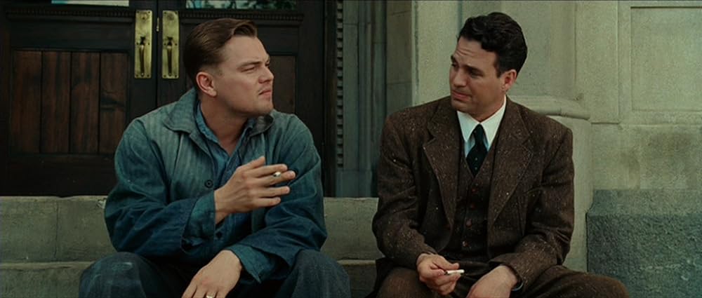 The concluding scene of "Shutter Island" features two men, Teddy Daniels (played by Leonardo DiCaprio) and Chuck Aule (portrayed by Mark Ruffalo), seated on steps, smoking cigarettes.
