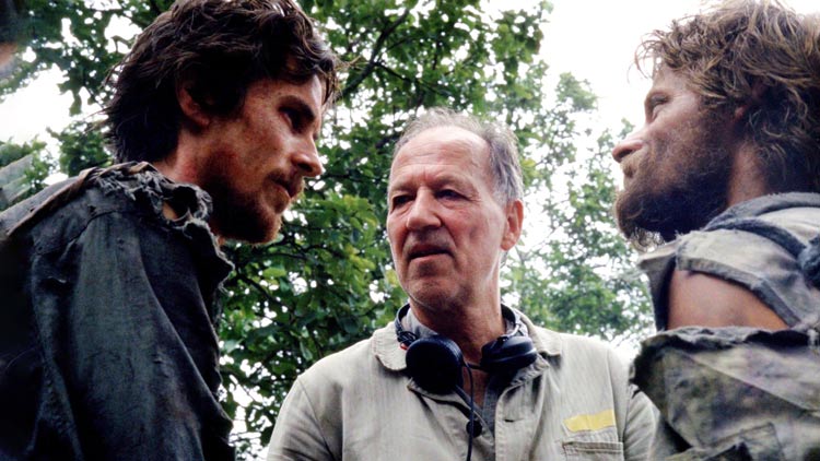 A behind-the-scenes moment from the movie "Rescue Dawn" featuring director Werner Herzog preparing actors Steve Zahn and Christian Bale for their roles.