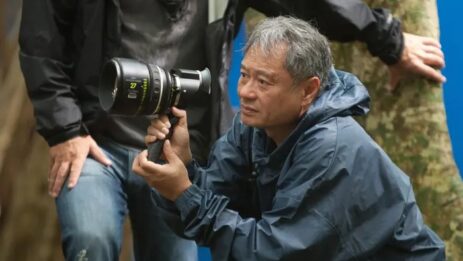 Director Ang Lee, donned in a raincoat, holding a camera in hand, on the movie set.