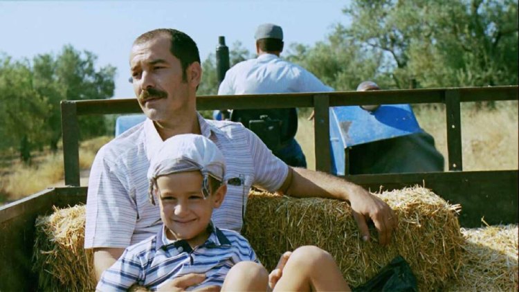 A heartwarming scene from the movie "Babam ve Oğlum" (My Father and My Son), where the father and son enjoy a delightful journey on the back of a tractor.