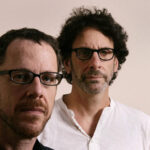 10 Signature Elements of Coen Brothers Filmmaking Style! Ethan Coen positioned in the foreground with Joel Coen in the background, creating a distinctive visual hierarchy.