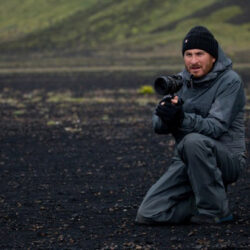 10 Signature Elements of Darren Aronofsky's Filmmaking Style! Director Darren Aronofsky in an outdoor setting, wielding a camera as he passionately directs a movie in the open land.