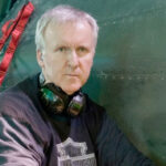 10 Signature Elements of James Cameron's Filmmaking Style! Director James Cameron immersed in directing a movie, wearing headphones for precise audio monitoring.