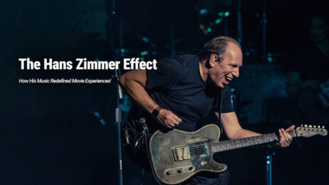 Hans Zimmer performing a concert with a guitar, visibly joyful, laughing, and enjoying the moment.