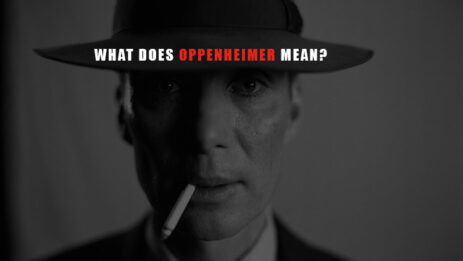 Image of Cillian Murphy as J. Robert Oppenheimer in the movie 'Oppenheimer,' wearing a hat and holding a cigarette, looking pensive with the text 'what does Oppenheimer mean?