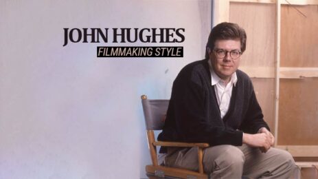 Director John Hughes seated in the director's chair, accompanied by the text "John Hughes filmmaking style."