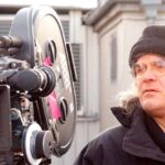 10 Signature Elements of Paul Greengrass’s Filmmaking Style! Director Paul Greengrass on the film set, focused behind the camera, actively directing a movie.
