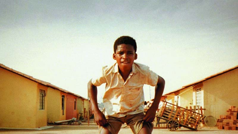 Captivating scene from 'City of God (Cidade de Deus)' featuring a child goalkeeper poised and ready to catch the ball in a moment of intense anticipation.